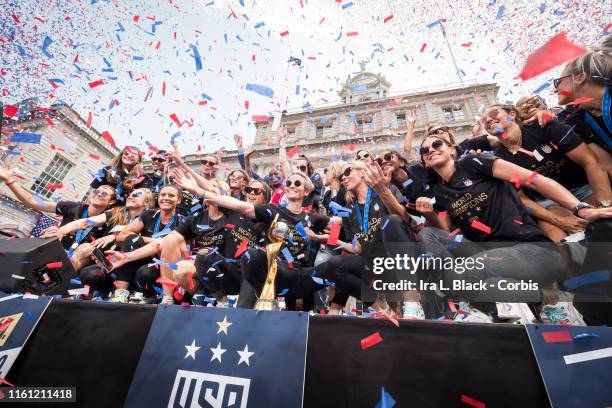 Members of the USA Women's National Soccer Team stand in front of the 2019 FIFA World Cup Trophy and get showered by confetti after the City Hall...