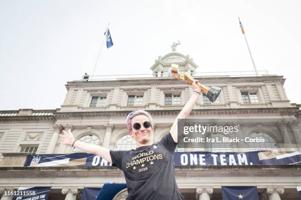 Megan Rapinoe of United States holds the 2019 FIFA World Cup Trophy and stands on the steps of City Hall after getting showered by confetti after the...