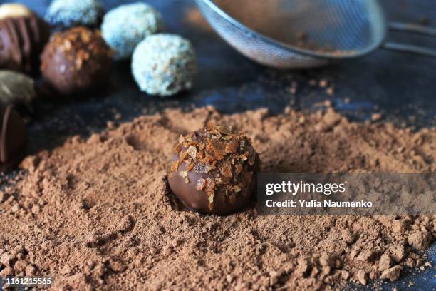 the process of making chocolate candies. andy on a table dusted with cocoa. - chocolate pieces stock-fotos und bilder