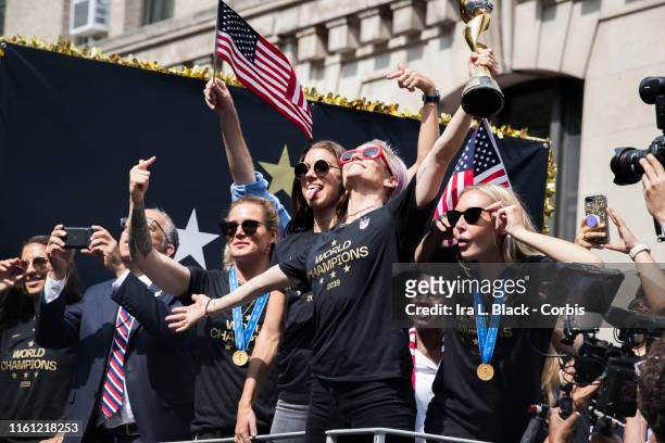 Megan Rapinoe of United States holds the 2019 FIFA World Cup Champion Trophy, Ashlyn Harris of United States Alex Morgan of United States and Allie...