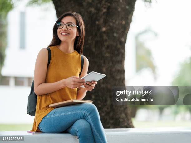 kvinnlig universitets student som innehar en liten tablett - read book outside young woman bildbanksfoton och bilder