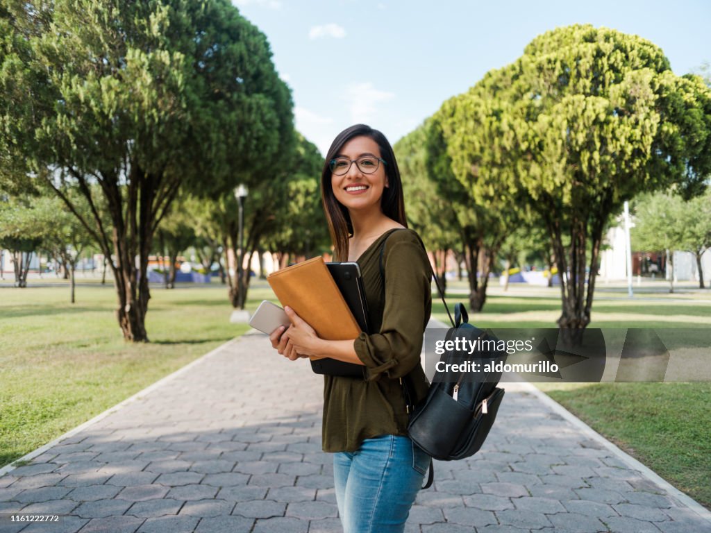 Latina College-Mädchen, das mit einem Lächeln in die Kamera schaut