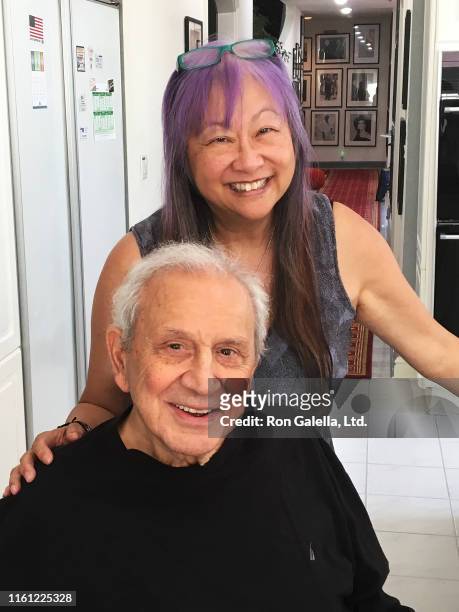 Portrait of American jewelry designer & talk show host May Pang and American photographer Ron Galella as they pose together in the latter's home,...