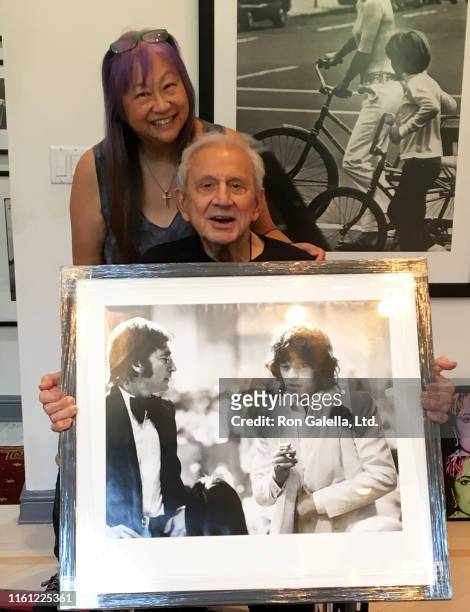 Portrait of American jewelry designer & talk show host May Pang and American photographer Ron Galella as they pose together in the latter's home,...