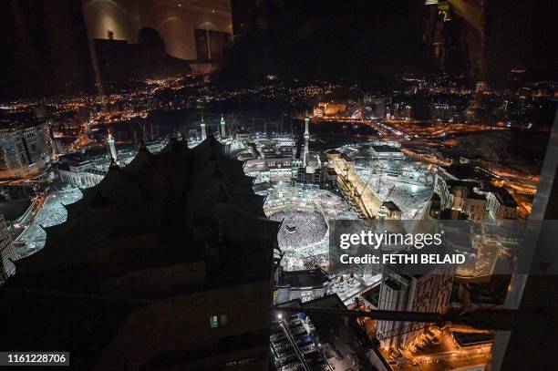 This picture taken on August 8, 2019 shows a night-time view from a room in a luxury hotel overlooking the Kaaba, Islam's holiest shrine, and its...