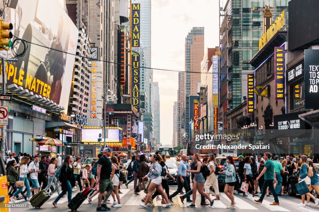Crowds of people crossing street on zebra crossing in New York, USA
