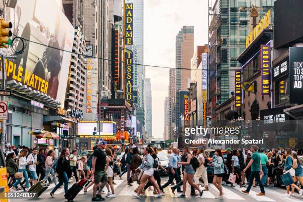 crowds of people crossing street on zebra crossing in new york, usa - folla foto e immagini stock
