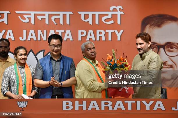 Haryana BJP President Subhash Barala offers a bouquet of flowers to Mahavir Phogat as he and his daughter and wrestler Babita Phogat join the BJP in...