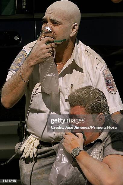 Paramedic and a policemen breath oxygen after the first tower of the the Twin Towers crumbled down after two planes hit the World Trade Center...