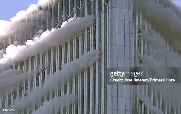 People hang from windows of World Trade Center after two hijacked passenger planes hit the building September 11, 2001 in New York City in an alleged...