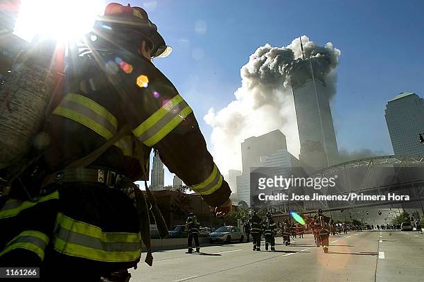 Firefighters walk towards one of the tower at the World Trade Center before it collapsed after a plane hit the building September 11, 2001 in New...