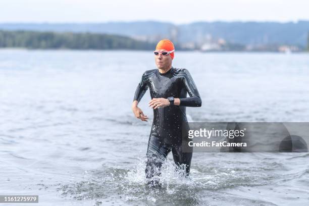 A female triathlete rushing out of the water