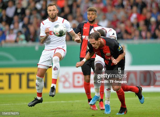 Marco Hoeger of 1. FC Koeln and Benedikt Roecker of SV Wehen Wiesbaden battle for the ball during the DFB Cup first round match between SV Wehen...