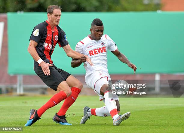 Benedikt Roecker of SV Wehen Wiesbaden and Jhon Cordoba of 1. FC Koeln battle for the ball during the DFB Cup first round match between SV Wehen...