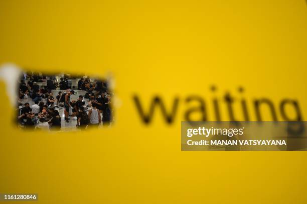 Pro-Democracy protesters wait in the arrivals hall of Hong Kong's international airport following a protest against police brutality and the...