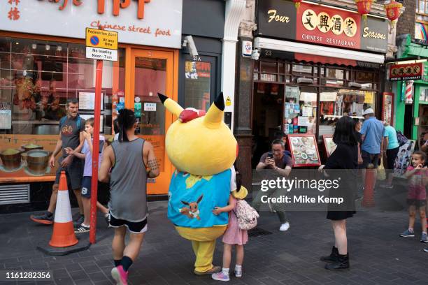 Pokemon Pikatchu who people pay to have their picture taken with in Chinatown, London, England, United Kingdom. Pikachu are a species of Pokemon,...