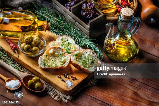 snack of voorgerecht van knoflook basilicum en olijfolie bruschetta op tafel in een rustieke keuken - garlic bread stockfoto's en -beelden