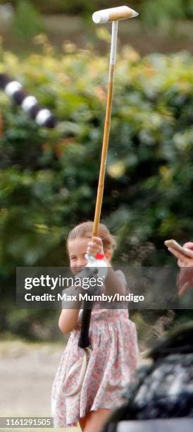 Princess Charlotte of Cambridge plays with a polo mallet as she attends the King Power Royal Charity Polo Match, in which Prince William, Duke of...