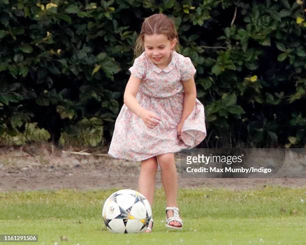 Princess Charlotte of Cambridge plays football as she attends the King Power Royal Charity Polo Match, in which Prince William, Duke of Cambridge and...
