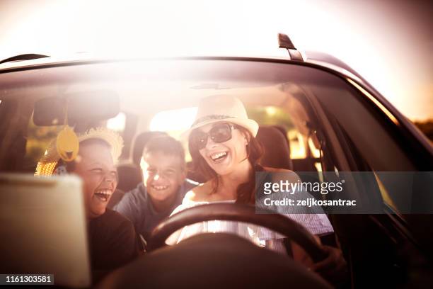 family driving in  car on countryside road trip - kids inside car stock pictures, royalty-free photos & images