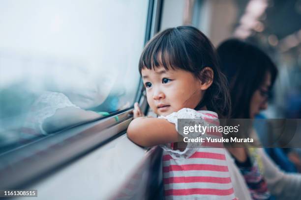 little girl looking out the window on train - teenager staring imagens e fotografias de stock