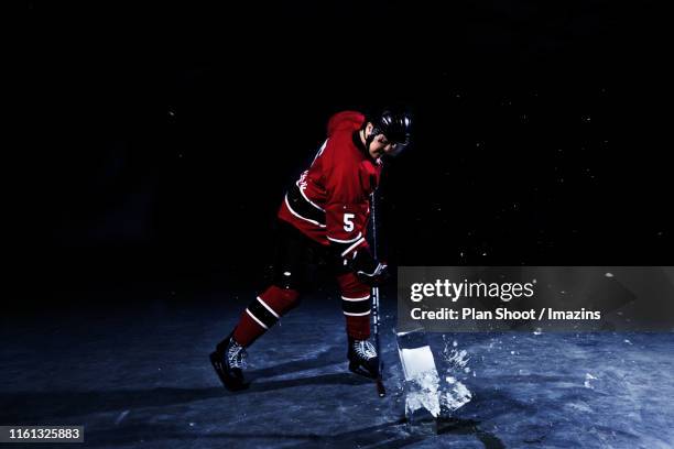 a young man posing like a hockey player - hockey player black background stock pictures, royalty-free photos & images