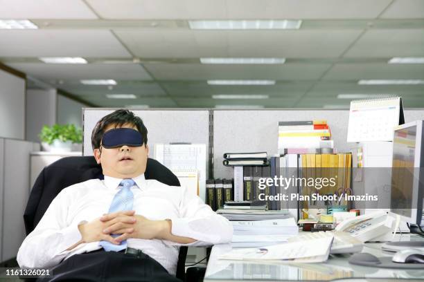 tired businessman sleeping at desk - computer wearing eye mask stock pictures, royalty-free photos & images