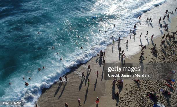 people enjoying at beach before sunset - bathing in sunset stock pictures, royalty-free photos & images