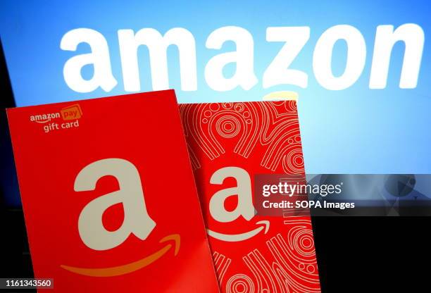In this photo illustration an American multinational technology company Amazon logo and gift cards seen being displayed.
