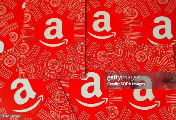 In this photo illustration an American multinational technology company Amazon logo and gift cards seen being displayed.