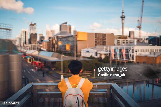 frau mit rucksack genießt den blick auf auckland. - auckland city people stock-fotos und bilder