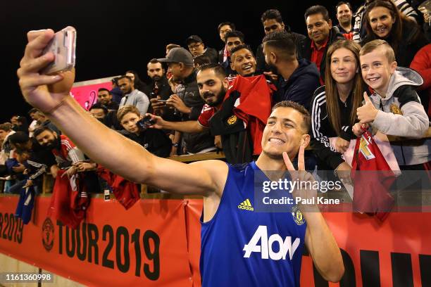 Diogo Dalot of Manchester United poses for a selfie with fans during a Manchester United training session at the WACA on July 11, 2019 in Perth,...