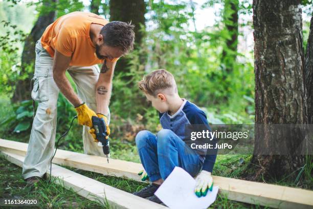 father and son working together - tree house stock pictures, royalty-free photos & images