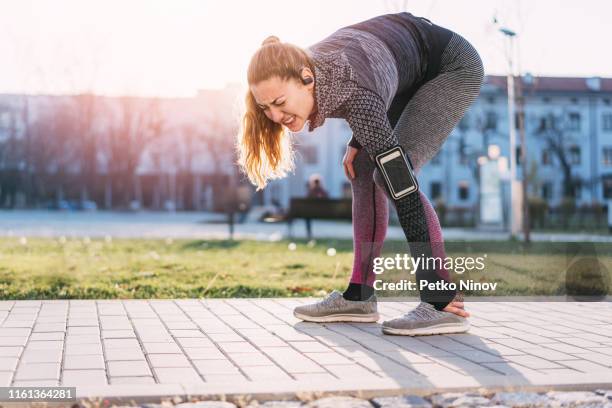 young woman injuring her left ankle - human foot stock pictures, royalty-free photos & images