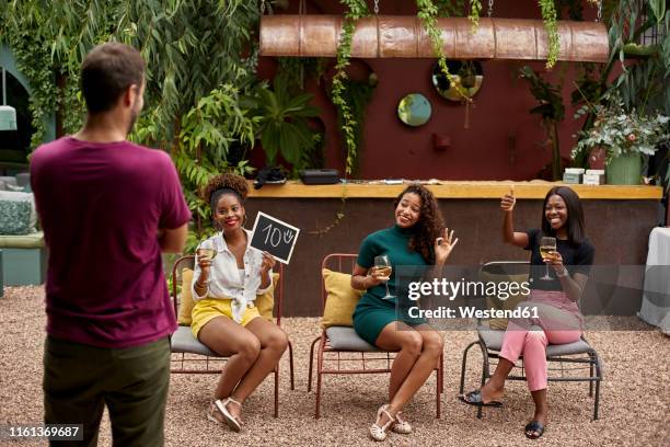 three young women rating a man, having fun - jury loisirs photos et images de collection