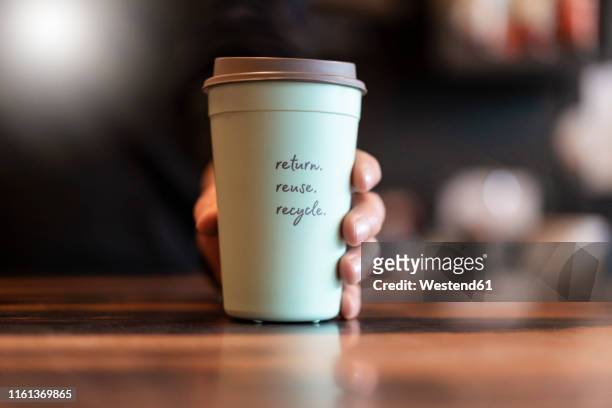 hand holding deposit cup for coffee to go, close-up - speisen oder getränke zum mitnehmen stock-fotos und bilder