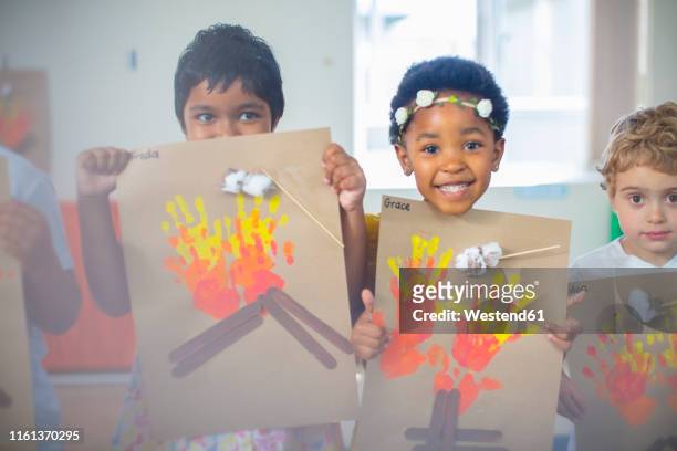 portrait of smiling children presenting images of fire in kindergarten - 4 girls finger painting 個照片及圖片檔