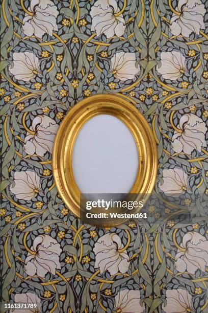 oval golden picture frame on wallpaper with art nouveau floral design - art nouveau stock pictures, royalty-free photos & images