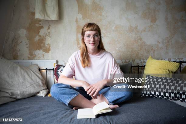 female student reading a book in her room - book flat stock pictures, royalty-free photos & images