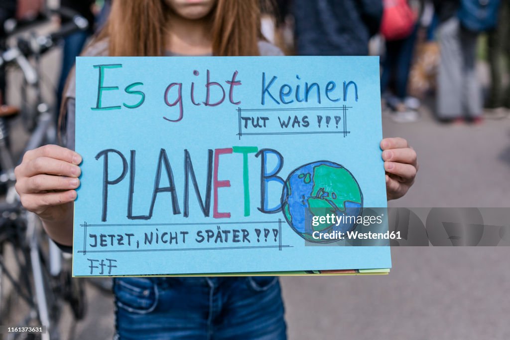 Girl holding a placard on a demonstration for environmentalism