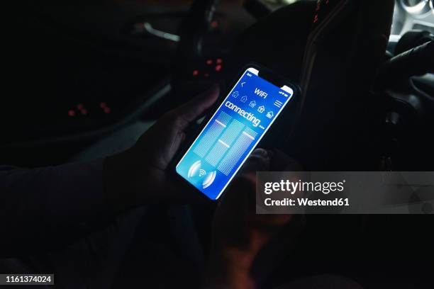 close-up of young man connecting smartphone with wifi in car at night - mobile phone in hand driving stock pictures, royalty-free photos & images