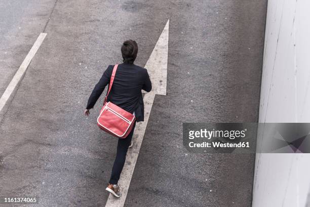 rear view of businessman running on road with arrow sign - runaway 個照片及圖片檔
