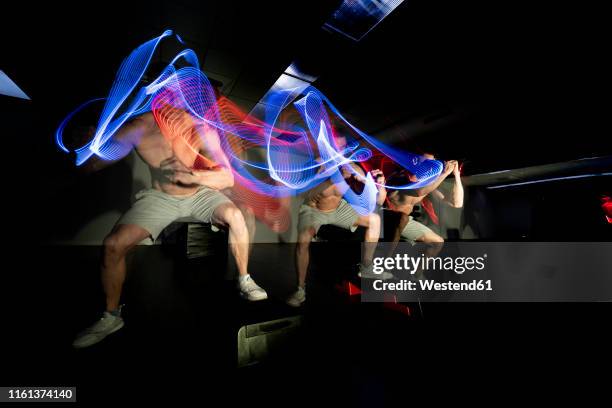 man practicing sport in dark area surrounded by colored lights - multiple exposure sport stock pictures, royalty-free photos & images