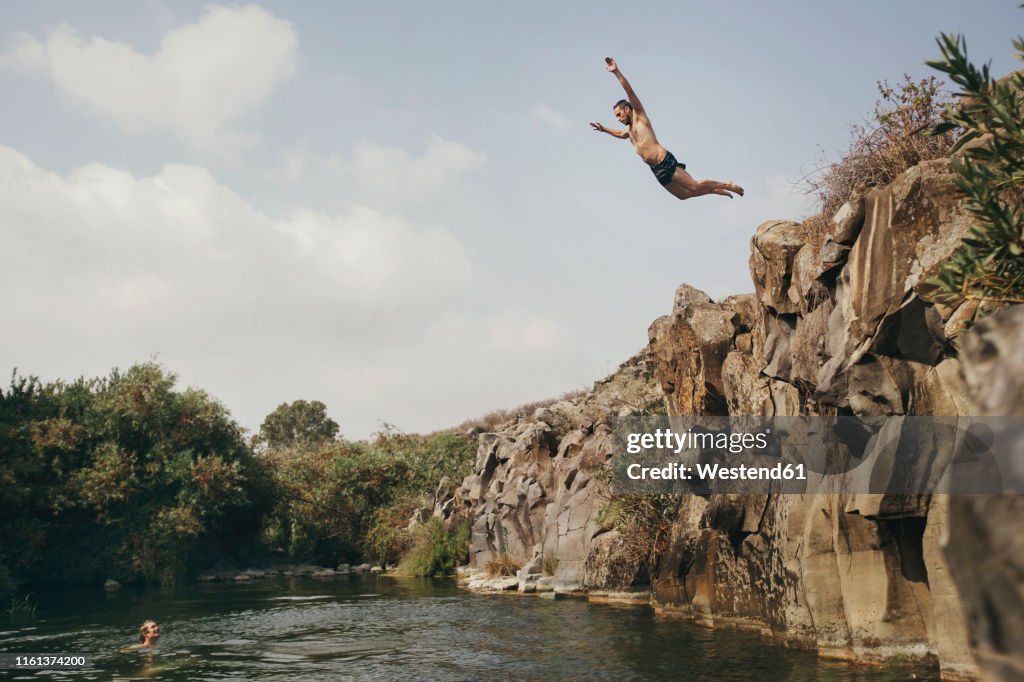 Young man jumping from a cliff, Yehudiya Reserve, Golan, Israel