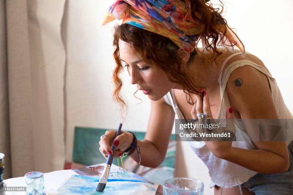 Young woman painting in art studio