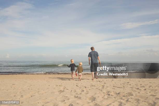 father with two kids on the beach - baltic states stock pictures, royalty-free photos & images