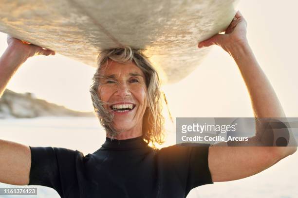 du bist nie zu alt, um neue abenteuer zu beginnen - beach hold surfboard stock-fotos und bilder