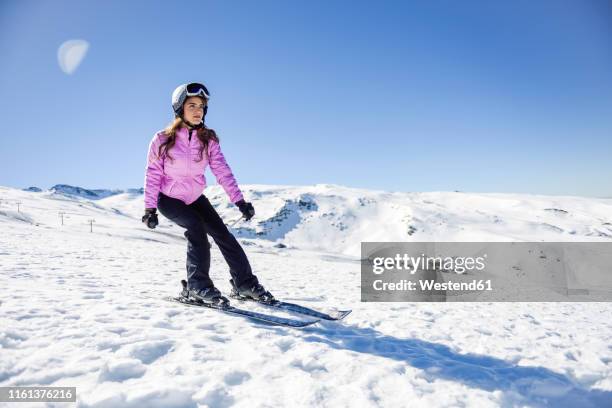 woman skiing under blue sky, sierra nevada, andalusia, spain - sierra nevada spain ski photos et images de collection