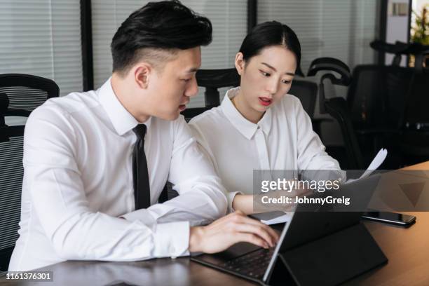 jeunes chefs d'entreprise asiatiques examinent attentivement les rapports - business talk petite phrase photos et images de collection