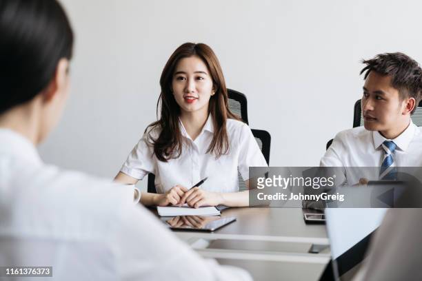 young chinese businesswoman conversing with colleagues - round table discussion stock pictures, royalty-free photos & images